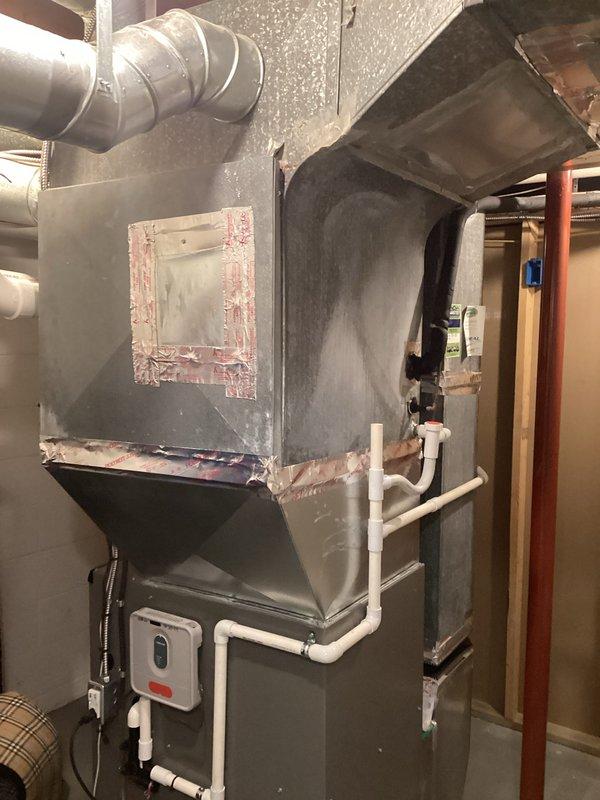 Conducted comprehensive evaluation of existing R22 residential HVAC system for replacement estimate. Assessed indoor air handler unit located in basement utility area and outdoor condensing unit positioned along exterior wall. Documented current system configuration including refrigerant line routing, electrical connections, condensate drainage, and ductwork connections. Photographed equipment conditions showing age-related wear on both indoor and outdoor components. Evaluated installation space constraints, existing infrastructure compatibility, and necessary modifications for new equipment installation. Provided detailed replacement recommendations accounting for R22 phase-out requirements and system upgrade options.