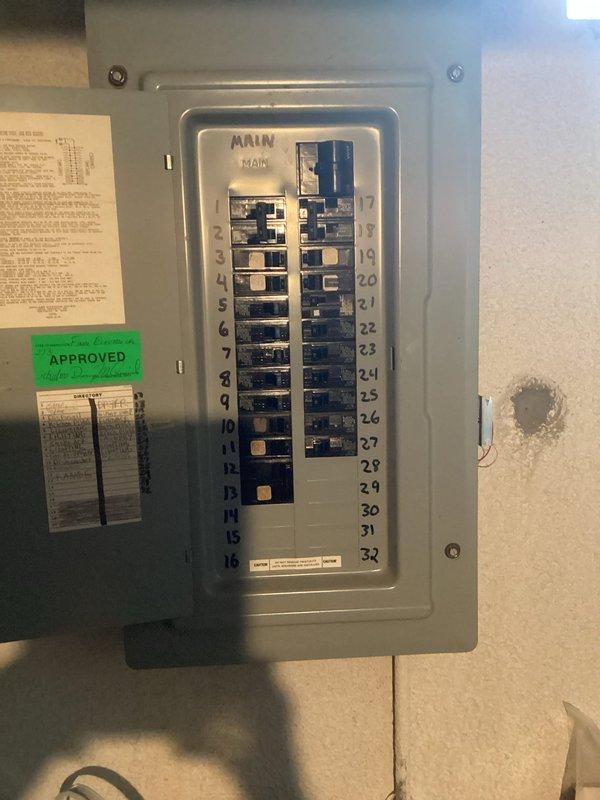 Performed electrical assessment of existing 32-circuit main breaker panel to provide estimate for DTE interruptible service connection or dedicated air conditioning circuit installation. Documented current panel configuration showing mixed breaker occupancy with available spaces for additional circuits. Panel directory indicates existing circuits serve standard residential loads including range, dryer, dishwasher, disposal, microwave, lighting circuits, receptacle circuits, smoke detectors, furnace, and sump pump. Photographed panel interior and circuit directory for estimate preparation purposes.