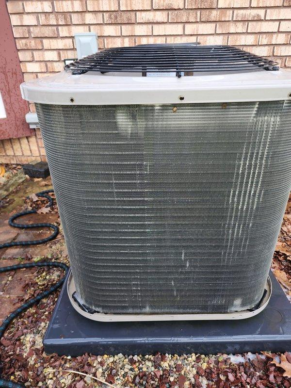 Completed comprehensive cooling system tune-up on a five-year-old air conditioning unit. Performed standard preventative maintenance procedures on both the outdoor condenser unit located at the rear of the property and the indoor air handler system. Inspected condenser coil fins for damage and debris accumulation, noting normal weathering consistent with outdoor exposure. Evaluated refrigerant line insulation and electrical connections at the indoor evaporator coil assembly. Verified condensate drain pan condition and proper drainage function. Documented system components through photographic records showing condenser unit positioned on concrete pad with decorative rock landscaping and indoor air handler installation with associated refrigerant lines and electrical wiring. All components found operating within normal parameters for a system of this age. Unit cleared for continued seasonal operation under maintenance agreement coverage.