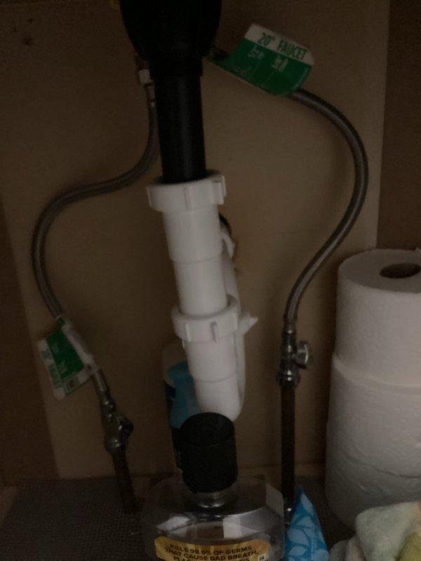 Responded to water hammer issue in half bath plumbing system that was causing water to shoot into kitchen when fixtures were used. Inspected under-sink plumbing connections and drainage assembly in main floor half bath, verifying proper installation of PVC drain lines, supply connections, and fixture mounting. Documented existing plumbing configuration with photos showing vanity sink assembly, faucet installation, and under-counter plumbing connections to assist with diagnosing the intermittent pressure surge problem that has persisted since water heater replacement six months prior.