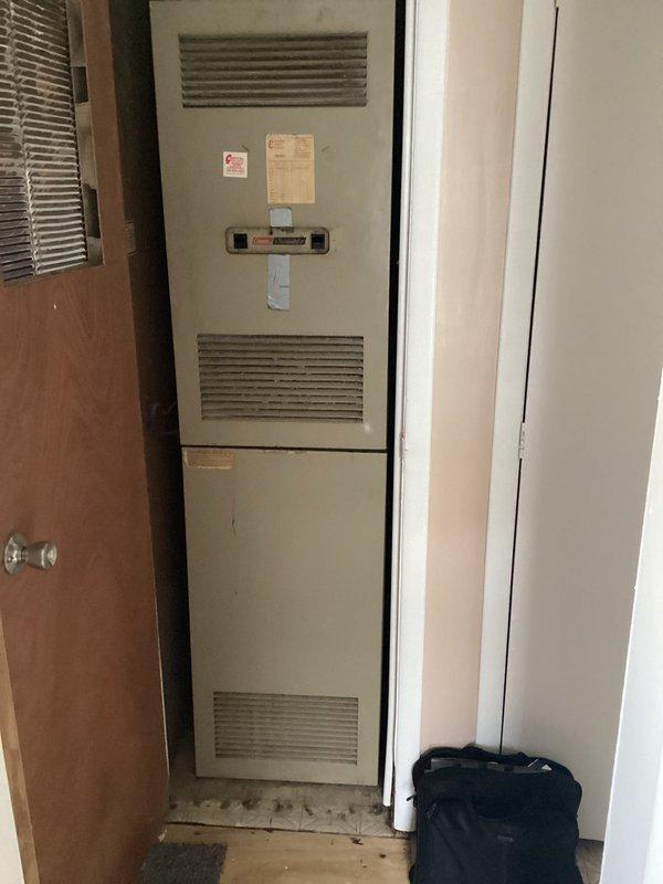 Conducted comprehensive HVAC system evaluation for new homeowner reporting cracked heat exchanger and complete air conditioning failure. Inspected vertical furnace/air handler unit installed in residential closet configuration, documented burner assembly, gas connections, and internal components to assess equipment condition and determine replacement requirements.