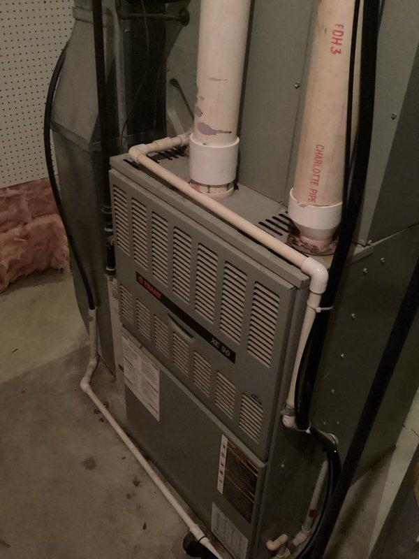 Conducted comprehensive HVAC system evaluation for equipment replacement estimate at residential property. Assessed existing outdoor air conditioning condenser unit mounted on concrete pad against exterior brick wall and indoor furnace system with PVC venting installed in basement utility area. Documented current equipment conditions, configurations, and installation requirements through detailed photographic documentation to provide accurate replacement system specifications and installation planning.