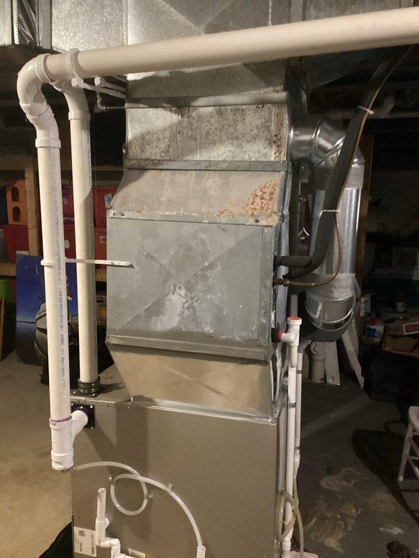 Completed estimate for air conditioning system replacement due to low R-22 refrigerant levels in existing unit. Assessed current basement installation consisting of Bryant furnace and older air handler with refrigerant lines, noting R-22 phase-out requiring full system replacement rather than recharge. Documented existing HVAC configuration including ductwork connections, PVC condensate drainage, and electrical connections to provide accurate replacement specifications and equipment recommendations.