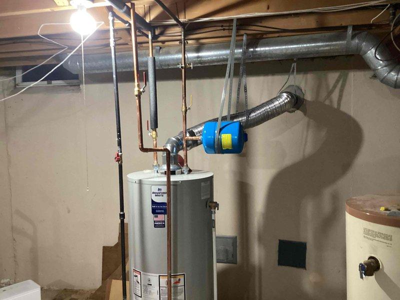 Successfully installed a 50-gallon Bradford White tanked water heater in the basement utility area. The installation included complete copper piping connections with brass fittings, proper venting through flexible metallic ductwork, and integration of a thermal expansion tank to protect the system from pressure fluctuations. All plumbing connections were secured with appropriate valving and supports, and the unit was tested for proper operation upon completion.