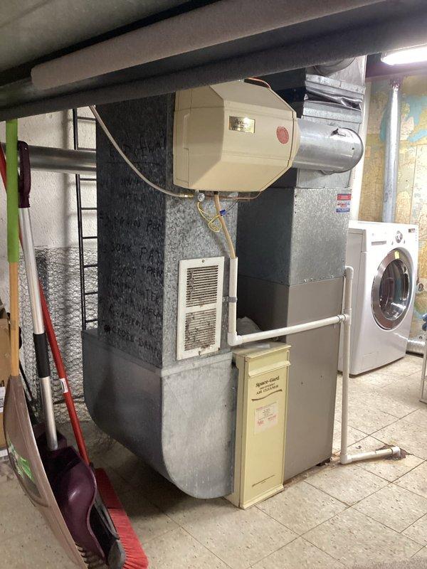 Completed furnace replacement estimate for residential basement installation. Assessed existing beige/tan furnace unit with metallic silver air handler, documented current HVAC configuration including ductwork with reflective insulation, and evaluated mechanical room layout accommodating water heater and laundry appliances. Provided comprehensive replacement quote for 10-12 SEER system within expedited timeframe to meet occupant scheduling requirements.