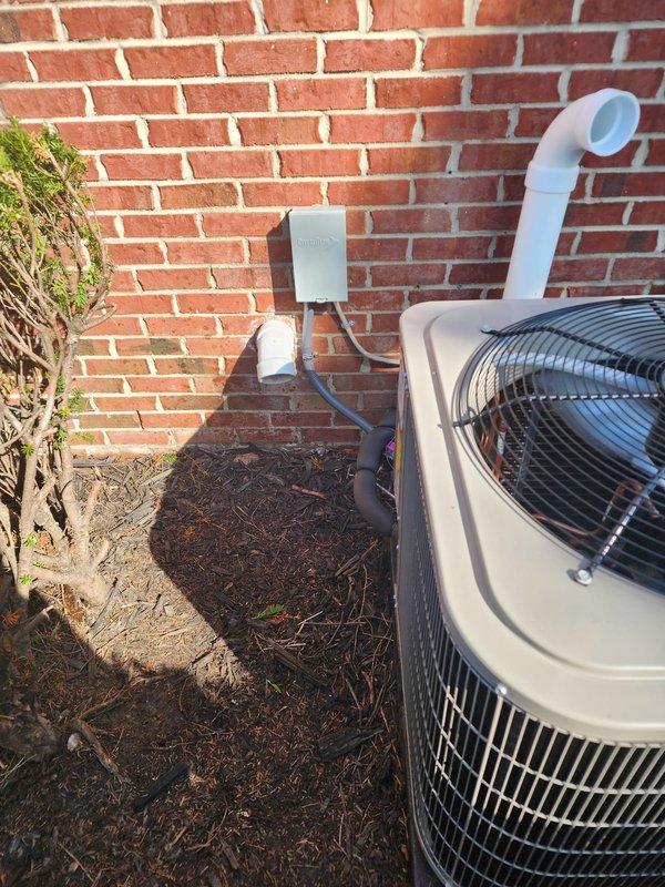Completed installation of Bryant air conditioning system at residential property. Mounted condensing unit on exterior pad against brick foundation with proper clearances for airflow and serviceability. Installed Diversitech electrical disconnect box on exterior wall with appropriate conduit routing and secured all electrical connections per manufacturer specifications and local code requirements. Ran condensate drain line using white PVC piping with proper pitch for drainage. Applied service identification labels to disconnect box for future reference. Verified system startup, refrigerant charge, and operational parameters. Unit tested and confirmed cooling operation within normal range.