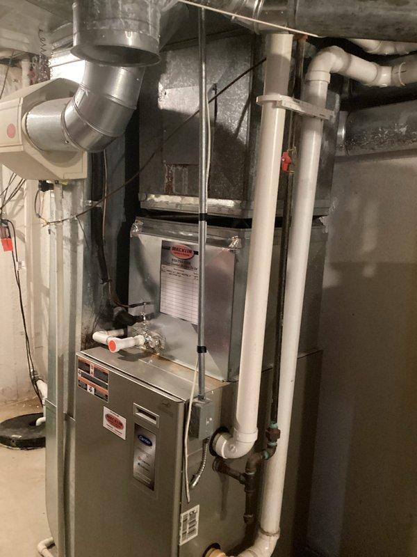 Conducted comprehensive on-site evaluation of existing residential HVAC system to provide replacement estimate for air conditioning unit. Inspected current gas furnace installation in basement mechanical room, documenting equipment condition, ductwork configuration, and existing infrastructure including PVC condensate drain lines and venting systems. Photographed all relevant components to assess compatibility requirements for new AC unit installation, noting proper clearances, electrical service availability, and connection points for refrigerant lines and condensate drainage.