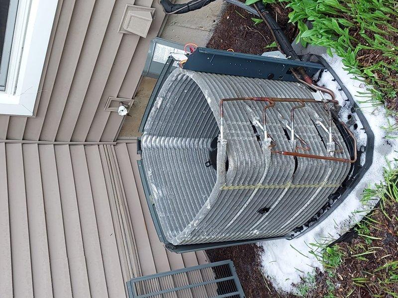 # HVAC Maintenance - Cooling System Service

Completed scheduled preventive maintenance on residential air conditioning system with barrel-style condenser unit. Performed comprehensive inspection of outdoor condensing unit, including visual assessment of cabinet condition, refrigerant line connections, and electrical components. Verified proper unit positioning on concrete pad and confirmed adequate clearance around equipment for optimal airflow. Inspected copper refrigerant lines for integrity and signs of wear, noting existing surface discoloration consistent with normal weathering. Checked condenser coil fins for damage, debris accumulation, and proper alignment. Evaluated electrical connections at control panel and verified secure conduit routing to building. Confirmed unit is operating within normal parameters and ready for cooling season demand.