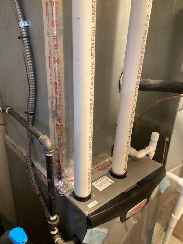 Conducted comprehensive replacement consultation for six-year-old furnace and water heater system installed in interior closet on slab foundation. Evaluated existing gray metal air handler with vertical PVC venting configuration, flexible metallic conduit, and associated gas piping connections. Documented current equipment specifications, photographed installation layout including white PVC drainage system and mounting configurations, and provided homeowner with replacement options for both units to address aging equipment concerns.
