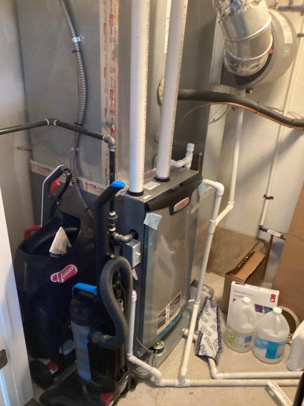 Conducted comprehensive replacement consultation for six-year-old furnace and water heater system installed in interior closet on slab foundation. Evaluated existing gray metal air handler with vertical PVC venting configuration, flexible metallic conduit, and associated gas piping connections. Documented current equipment specifications, photographed installation layout including white PVC drainage system and mounting configurations, and provided homeowner with replacement options for both units to address aging equipment concerns.