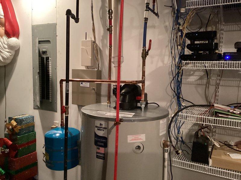 Completed installation of 75-gallon power vent tank-type water heater in basement utility area. Installation included connecting hot and cold water supply lines using PEX and copper piping, installing blue expansion tank for thermal expansion protection, and routing power vent exhaust system. All plumbing connections were properly secured with appropriate fittings, and the unit was tested for proper operation and leak-free performance upon completion.
