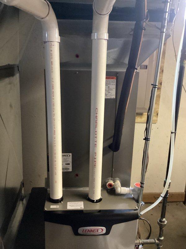 Provided estimate for complete HVAC system replacement in residential basement mechanical room. Assessed existing Lennox furnace installation with current PVC venting configuration, copper refrigerant lines, and electrical connections to determine replacement specifications and requirements for new equipment installation.