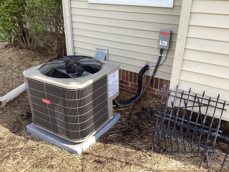 Completed full installation of Bryant air conditioning system at residential property. Installed outdoor condenser unit on concrete pad with proper clearances from structure, mounted electrical disconnect box on exterior wall with conduit run, and installed Honeywell digital programmable thermostat inside residence. System tested and verified operational, with all electrical connections secured and unit cycling properly through cooling modes.