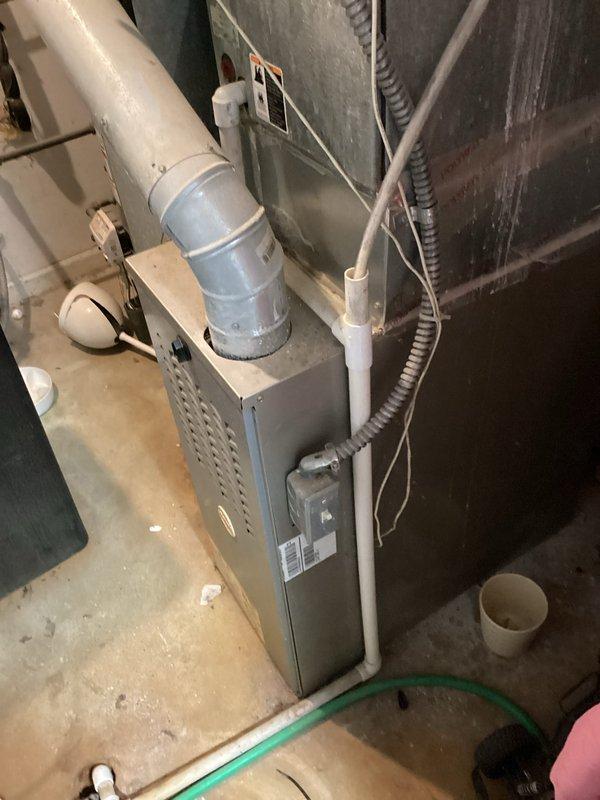 Conducted on-site evaluation for replacement of 32-year-old residential air conditioning system located on side of single-family, owner-occupied home. Assessed existing outdoor condensing unit placement, electrical service connections including dual meter configuration and associated disconnect boxes, and indoor air handler integration with existing furnace and ductwork system. Documented current equipment condition, electrical infrastructure, and HVAC system layout including galvanized and flexible duct connections, PVC condensate piping, and basement installation configuration to provide comprehensive replacement estimate for new AC unit installation.