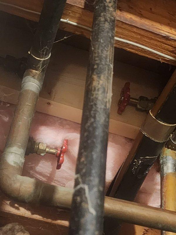 Responded to water heater leak service call and accessed plumbing system in attic space. Upon inspection, identified active leak on tanked water heater connections. Evaluated corroded vertical supply piping and associated copper water lines with shut-off valves. Repaired leak at connection point, tested system for proper operation, and verified no additional leaks present. All plumbing components restored to normal function.