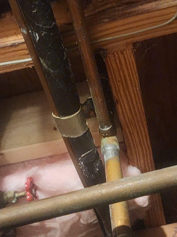 Responded to water heater leak service call and accessed plumbing system in attic space. Upon inspection, identified active leak on tanked water heater connections. Evaluated corroded vertical supply piping and associated copper water lines with shut-off valves. Repaired leak at connection point, tested system for proper operation, and verified no additional leaks present. All plumbing components restored to normal function.