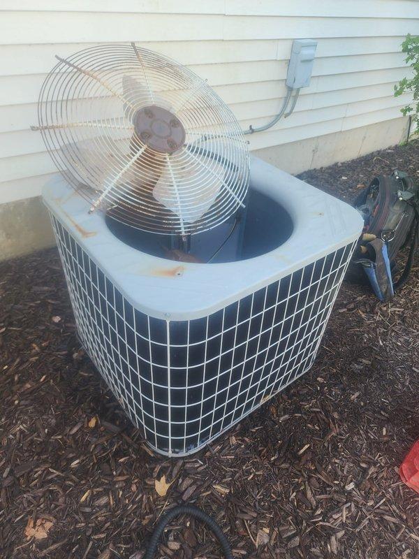 Completed routine air conditioning maintenance on residential cooling system. Performed comprehensive inspection of outdoor condenser unit, including examination of compressor, condenser coils, and electrical connections. Inspected compressor housing showing normal age-related oxidation and confirmed proper mounting on base pan. Evaluated condenser coil condition, noting minor fin discoloration consistent with outdoor exposure. Verified electrical wiring connections secure and intact. Checked drain pan for proper drainage and debris accumulation. Assessed overall unit operation and confirmed system functionality. Unit shows typical wear patterns for age but remains operational within normal parameters.