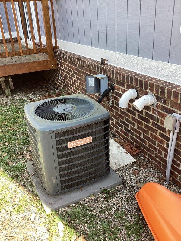 Conducted site assessment for air conditioning replacement estimate on non-operational 12-year-old Goodman condenser unit located on exterior concrete pad. Evaluated existing outdoor equipment, electrical panel configuration, and circuit breaker setup to determine specifications for replacement system installation.