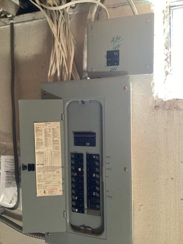 Conducted site assessment for air conditioning replacement estimate on non-operational 12-year-old Goodman condenser unit located on exterior concrete pad. Evaluated existing outdoor equipment, electrical panel configuration, and circuit breaker setup to determine specifications for replacement system installation.