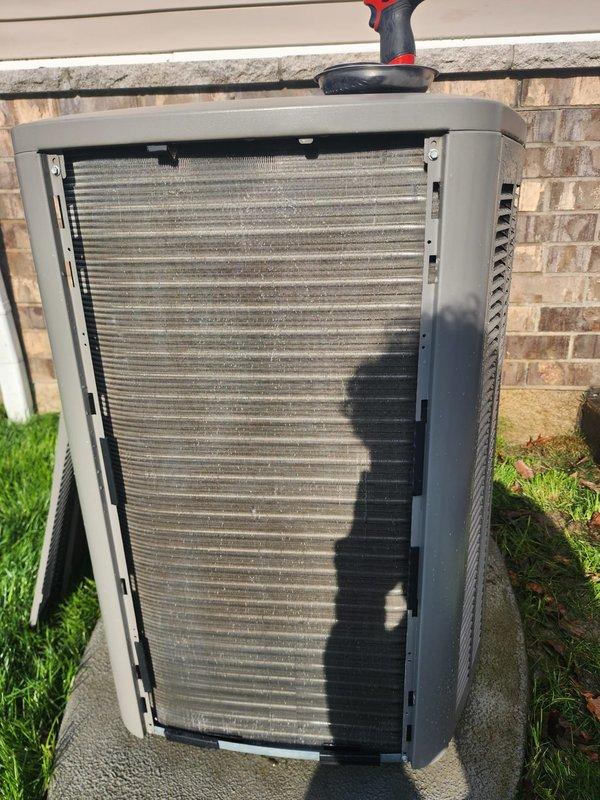 Completed annual AC maintenance tune-up on residential cooling system as part of prepaid maintenance plan. System was operational upon arrival. Accessed outdoor condenser unit, removed front panel to inspect internal components. Condenser coils showed significant dust and debris accumulation with heavy grime buildup on fins. Performed thorough cleaning of condenser coils and fins to restore proper airflow and heat transfer efficiency. Inspected compressor, refrigerant lines, electrical connections, and wiring—all components found to be in satisfactory working condition. Reassembled unit and verified system operation. Documentation photos captured for service records.
