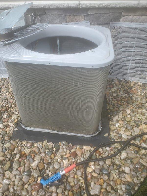 Completed scheduled air conditioning maintenance on two outdoor condenser units. Performed standard inspection of cylindrical condensers, verified proper operation of both units, and inspected refrigerant line insulation. Checked drain pan condition and documented evidence of normal moisture accumulation with minor sediment present. All components found operating within normal parameters.
