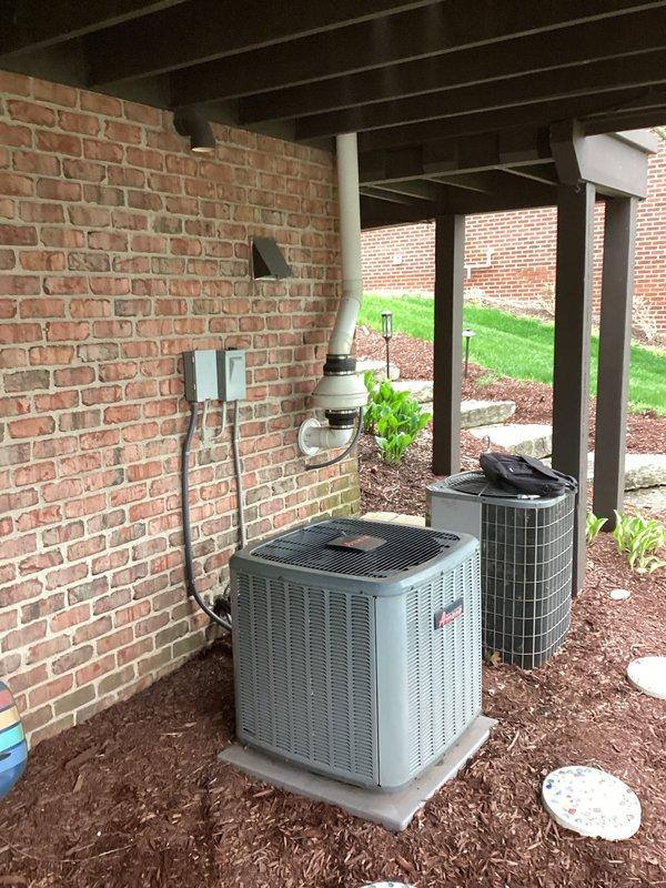 Responded to service call for non-cooling air conditioning system at single-family residence. Evaluated existing 15+ year old 3-ton Amana condenser unit located in backyard beneath deck structure on concrete pad. Unit positioned against brick wall with electrical disconnect and line set protection visible. Documented equipment condition and installation setup including secondary HVAC unit adjacent to primary system. Prepared replacement estimate for aging air conditioning system per homeowner request. Captured photographic documentation of existing equipment, electrical connections, condensate drain lines, and surrounding installation area for quote preparation purposes.