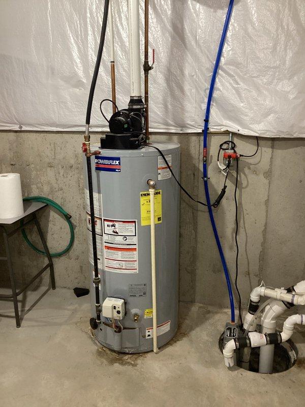 Completed water heater estimate for replacement of existing PowerFlex unit in basement utility area. Assessed current installation including pump assembly, copper supply lines, PVC drainage system, and blue PEX distribution piping. Documented existing configuration with concrete floor placement, electrical connections, and plumbing infrastructure routing through ceiling joists to prepare comprehensive replacement proposal.