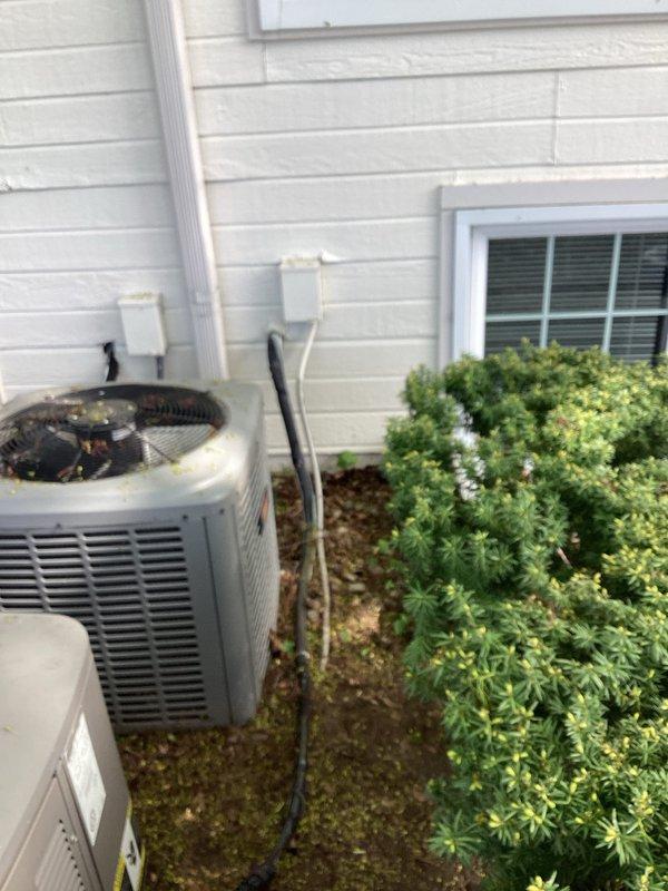 Conducted comprehensive assessment of existing dual HVAC system consisting of two outdoor condenser units showing significant age-related deterioration. Both units exhibited heavy debris accumulation on fan grilles including pollen, leaves, and dirt, along with visible moss and algae growth on concrete pads indicating extended service life. Evaluated the 11-12 year old Lennox condenser unit and secondary unit, noting exterior weathering, compromised cabinet condition, and overall system degradation consistent with equipment nearing end of useful service life. Documented equipment configuration including refrigerant line routing, electrical connections via junction boxes, and current installation positioning against building exterior. Provided detailed replacement estimate based on observed equipment age, declining operational efficiency, and preventive maintenance considerations to avoid potential system failure.