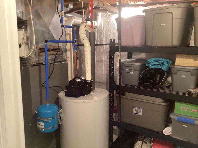 Completed installation of a 50-gallon tanked water heater in basement mechanical room. Established all necessary water supply connections using blue PEX piping and copper lines, installed pressure tank, and integrated new unit with existing plumbing infrastructure. System was tested, verified operational, and customer payment was collected upon completion.