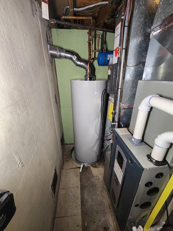 Successfully installed a new 50-gallon tanked water heater in the basement mechanical room. The installation included proper copper pipe connections at the inlet and outlet, integration with the existing plumbing system, and installation of a blue expansion tank to accommodate thermal expansion and maintain proper system pressure. All connections were secured with appropriate fittings and valves to ensure code compliance and optimal performance.

Additionally, replaced the humidifier valve as part of the service call. The new valve was installed to restore proper function to the home's humidification system. All work was completed in the confined basement utility area alongside existing HVAC equipment and ductwork. The water heater was positioned on the concrete floor with adequate clearance for ventilation and future maintenance access. System was tested and verified operational upon completion.