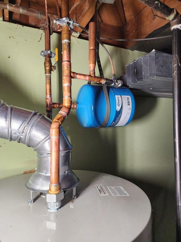 Successfully installed a new 50-gallon tanked water heater in the basement mechanical room. The installation included proper copper pipe connections at the inlet and outlet, integration with the existing plumbing system, and installation of a blue expansion tank to accommodate thermal expansion and maintain proper system pressure. All connections were secured with appropriate fittings and valves to ensure code compliance and optimal performance.

Additionally, replaced the humidifier valve as part of the service call. The new valve was installed to restore proper function to the home's humidification system. All work was completed in the confined basement utility area alongside existing HVAC equipment and ductwork. The water heater was positioned on the concrete floor with adequate clearance for ventilation and future maintenance access. System was tested and verified operational upon completion.