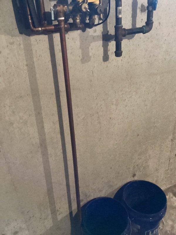 Conducted on-site assessment for tankless water heater replacement in basement utility area. Evaluated existing wall-mounted tankless unit with exposed internal components, including copper piping, gas connections, and electrical wiring. Documented current installation configuration, noting water inlet/outlet connections, venting requirements, and mounting location on concrete wall. Assessed plumbing manifold system with copper and PEX distribution lines, as well as existing valve assembly and water distribution infrastructure to determine compatibility requirements for replacement unit.