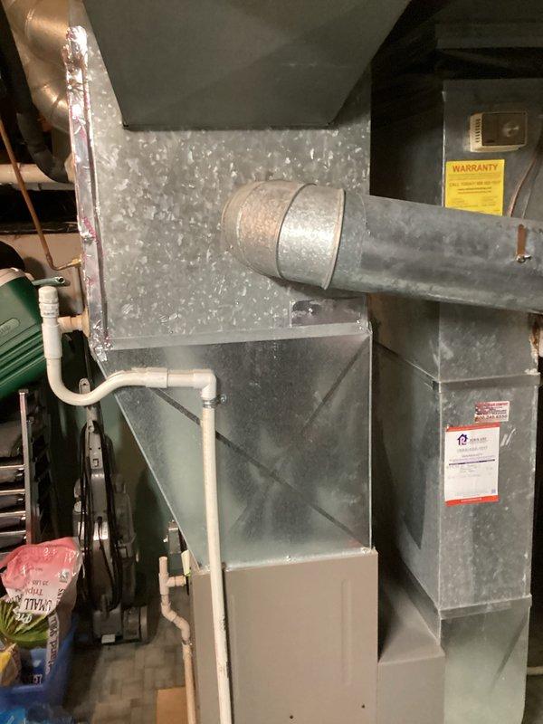 Responded to red tag furnace with multiple holes in heat exchanger. Provided replacement estimate for complete HVAC system due to failed heat exchanger posing safety hazard. Documented existing equipment configuration including furnace, humidifier, ductwork, and condensate drainage system with photos for customer records.