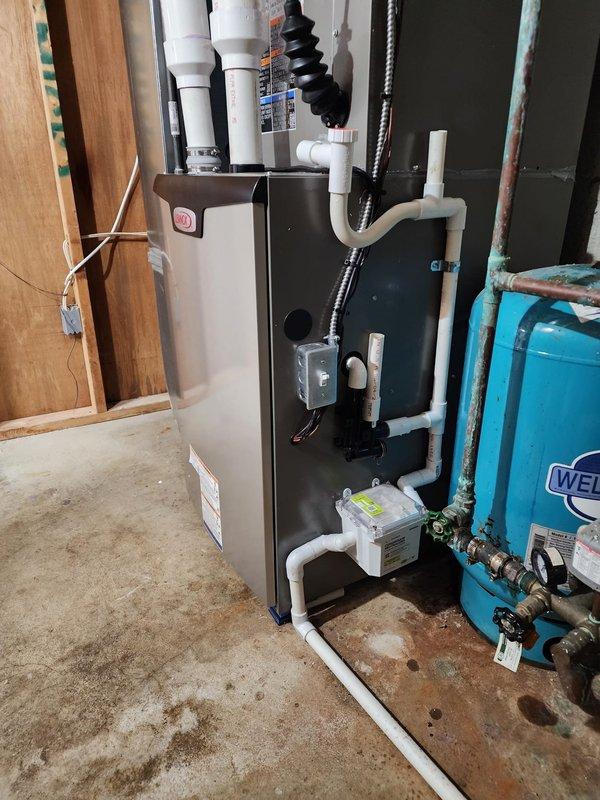 # HVAC System Installation Summary

Successfully completed full residential HVAC system installation including Lennox high-efficiency furnace, air conditioning unit, S40 smart thermostat, and Air Scrubber air purification system.

# Work Performed

Installed new Lennox furnace in basement utility area with proper clearances and mounting on concrete pad. Connected complete PVC venting system with multiple elbows and joints for intake and exhaust, ensuring code-compliant configuration for high-efficiency operation. Installed black flexible ductwork connections to integrate with existing distribution system. Routed and secured vertical supply ductwork along basement framing.

Installed corresponding Lennox air conditioning condenser unit with refrigerant line connections to indoor coil. Completed all electrical connections for both heating and cooling components, ensuring proper voltage and amperage specifications.

Mounted S40 smart thermostat at designated location with proper wiring to