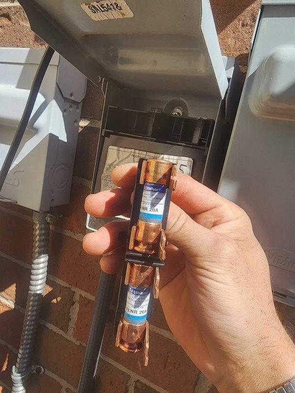 Responded to callback for electrical code violation on A/C disconnect. Previous inspection identified incorrect fuse amperage exceeding nameplate maximum overcurrent protection rating. Replaced oversized fuses with proper 20-amp non-renewable time-delay fuses to match equipment specifications and bring installation into code compliance. Verified correct fuse sizing against unit nameplate requirements. Documented corrected installation with photographs showing proper fuses installed in outdoor disconnect box. System now meets National Electrical Code requirements for overcurrent protection.