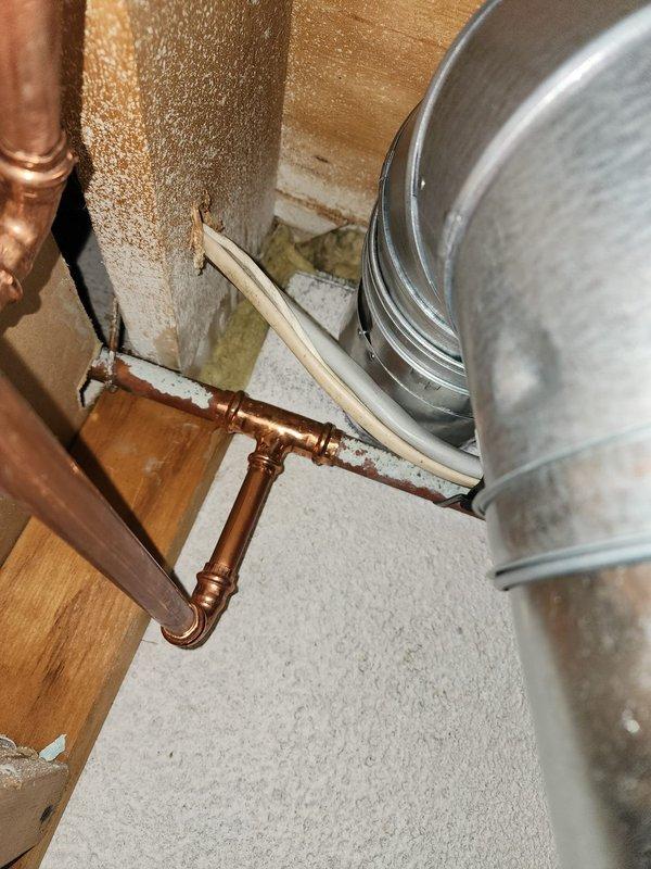 Responded to callback for furnace exhaust code compliance issue. Inspected single-wall exhaust ductwork at ceiling level and verified clearance measurements to combustible materials and electrical wiring. Documented existing conditions with photographs showing flexible metallic ductwork installation, transition fittings, and proximity to ceiling joists and insulation. Completed follow-up documentation for reinspection scheduling to ensure 6-inch clearance requirements are met per code specifications.