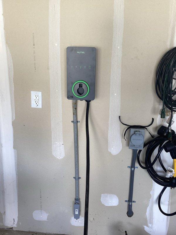 Installed a new 60-amp, 240-volt dedicated circuit from the existing main service panel in the basement to the garage for electric vehicle charging. Ran copper conductors through conduit and hardwired a customer-supplied Autel EV charging station to the wall adjacent to the existing generator inlet location. Successfully completed electrical installation with proper circuit protection, passed inspection, and verified charger operational status with green indicator illuminated.