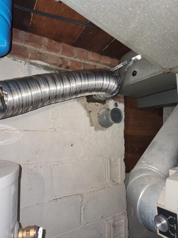 Completed installation of flexible metallic chimney liner in basement utility area, securing ductwork to ceiling structure with proper mounting brackets and connectors. The liner was routed through the existing masonry chimney chase and connected to the HVAC system, ensuring proper ventilation and code compliance. All components were installed and verified for structural integrity and operational functionality.