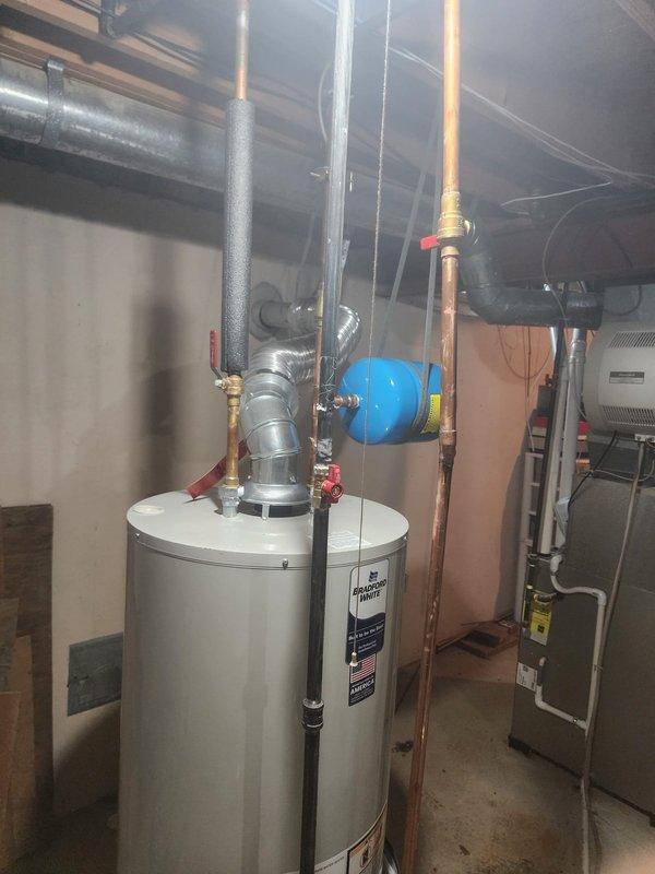 Responded to callback regarding hot water heater experiencing extended heating time of 20 minutes. Upon inspection, verified water heater installation, expansion tank, and associated copper piping connections in basement mechanical room. Documented equipment condition and plumbing configuration with photos showing proper mounting, valve placement, and system components functioning as installed.