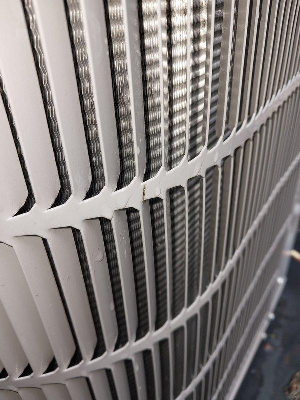 Completed comprehensive cooling system maintenance and hot water tank servicing. Inspected outdoor condenser unit with clean coils and louvers showing proper airflow and no debris accumulation. Examined indoor air handler components including drain pan with standing condensate, refrigerant lines, and electrical connections, confirming all systems operational and properly secured.