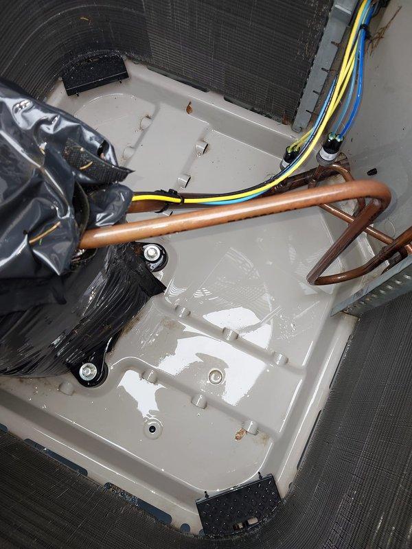 Completed comprehensive cooling system maintenance and hot water tank servicing. Inspected outdoor condenser unit with clean coils and louvers showing proper airflow and no debris accumulation. Examined indoor air handler components including drain pan with standing condensate, refrigerant lines, and electrical connections, confirming all systems operational and properly secured.