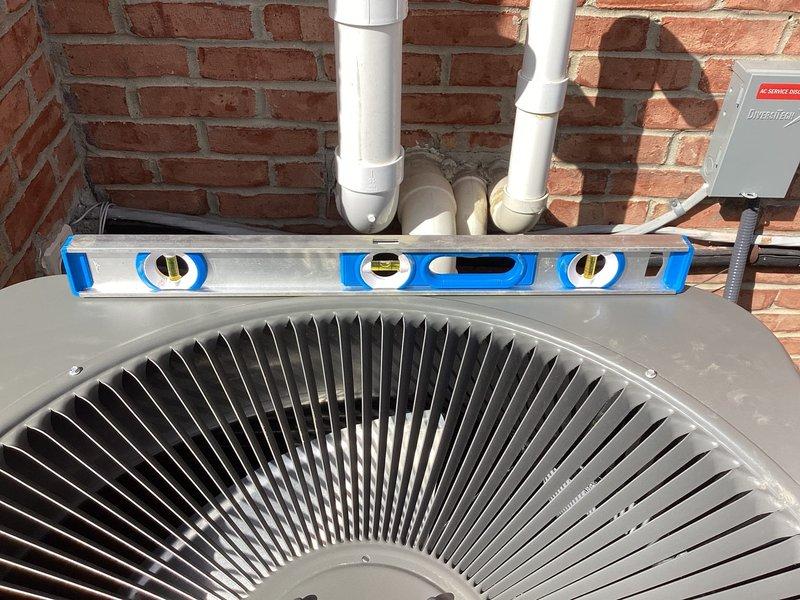 Leveled Lennox air conditioning unit on pad using precision spirit level to ensure proper installation alignment and drainage. Completed comprehensive AC start-up procedure, verifying system operation, refrigerant levels, electrical connections at disconnect box, and airflow through condenser coils. Unit tested and confirmed operational for cooling season.