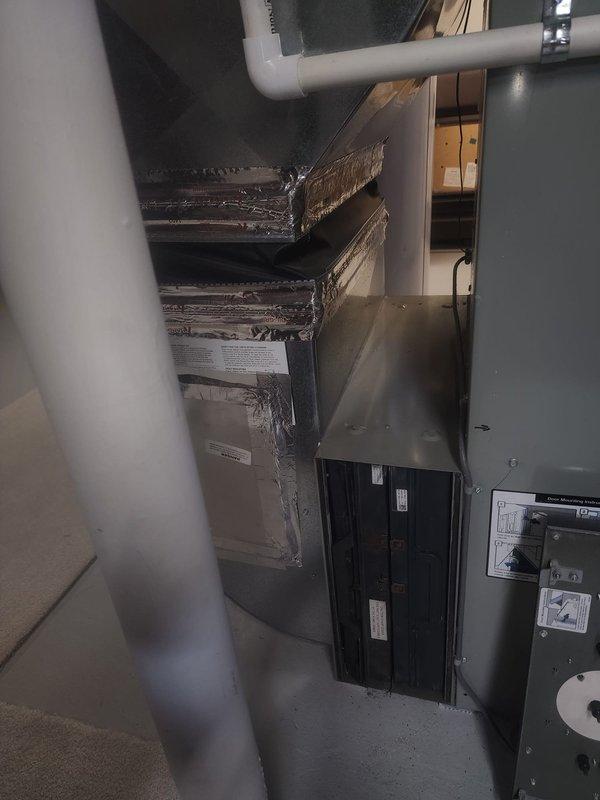 Performed site assessment of existing HVAC air handler system with electric filter cabinet to provide upgrade quote for conversion to standard filter configuration. Documented current equipment setup including air handler unit, ductwork connections, and electrical components. Captured photographs of mechanical space showing existing filter cabinet installation, reflective insulated ductwork, and associated electrical panel for estimation purposes.