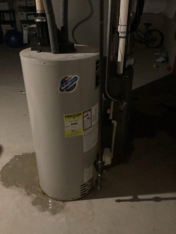 Completed estimate for hot water heater replacement in basement utility area. Assessed existing white cylindrical water heater with circulator pump mounted on top, evaluated current plumbing connections including both copper and PVC piping, and documented moisture staining on concrete floor around unit base. Provided customer with replacement options and specifications for new water heater installation.
