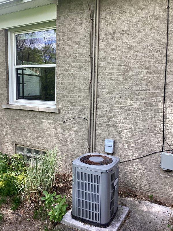 Provided replacement estimate for residential R22 air conditioning system experiencing freezing conditions. Assessed existing outdoor condensing unit installed on concrete pad against exterior wall, documented current system configuration including refrigerant lines, electrical disconnect, and conduit routing. Presented multiple equipment replacement options to address obsolete R22 refrigerant and resolve freezing issue.