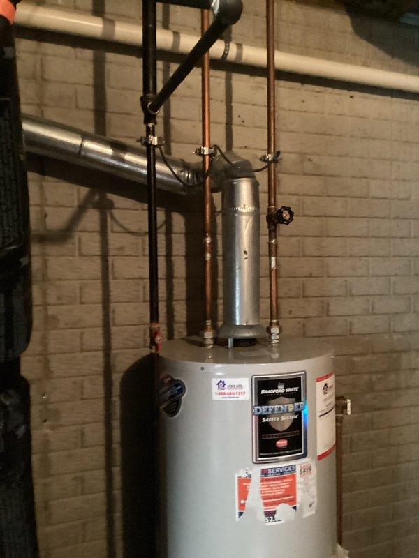 Completed on-site assessment for water heater replacement in basement utility area. Evaluated existing water heater installation including current plumbing configuration with copper supply lines, pressure relief valve discharge piping, and vertical expansion tank mounted above unit. Documented equipment access constraints due to narrow clearances between painted brick walls and adjacent ductwork in confined mechanical space. Photographed existing installation setup and provided estimate for replacement water heater with necessary plumbing connections and code-compliant installation.