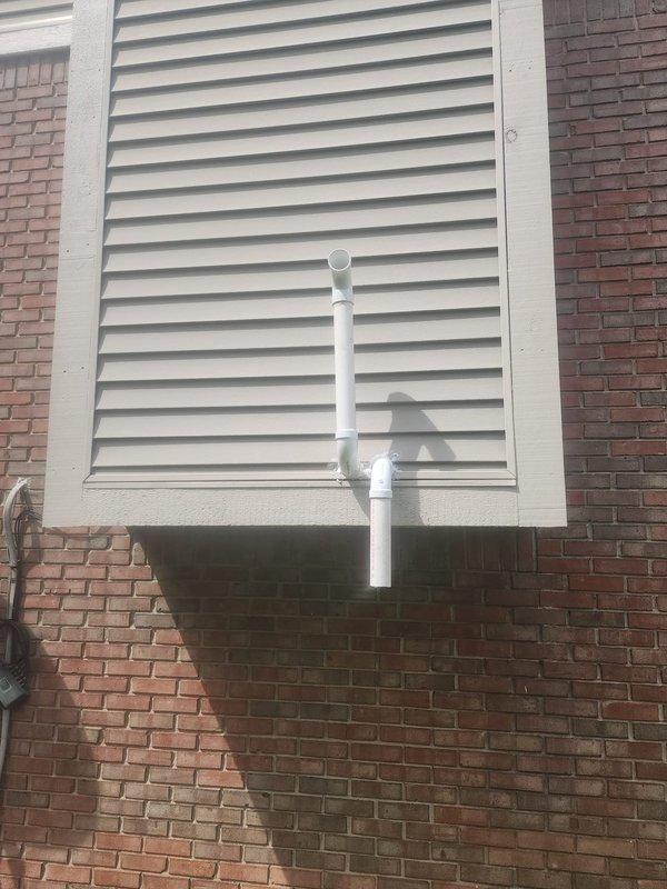 Responded to indoor air quality concerns regarding dry eyes and stomach issues when HVAC system operates. Inspected exterior ventilation terminations and PVC vent piping system for potential contamination or pest intrusion. Examined white louvered vent panel mounted on brick exterior wall and associated drainage/ventilation piping runs. No visible signs of pest infiltration, debris blockage, or compromised vent integrity observed during exterior inspection.