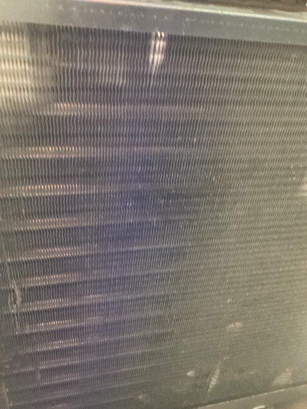 Completed scheduled cooling system maintenance and tune-up on HVAC unit. Inspected evaporator coil and heat exchanger, noting normal operational wear with dust accumulation on fins. Verified system operation, checked condensate drainage system with PVC fittings, and documented equipment condition with photos. System confirmed working properly upon completion.