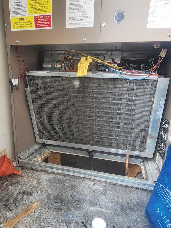 # HVAC Maintenance - Cooling System Service

Performed comprehensive preventive maintenance on residential air conditioning unit. Accessed interior compartment and inspected evaporator coil, which exhibited moderate accumulation of dust and debris between fins. Examined electrical connections, wire harnesses, and control components in upper compartment section, verifying all connections were secure and properly terminated. Inspected mounting hardware, support blocks, and cabinet interior for structural integrity and proper installation. All safety labels and warning placards confirmed present and legible. Unit operational following maintenance procedures.