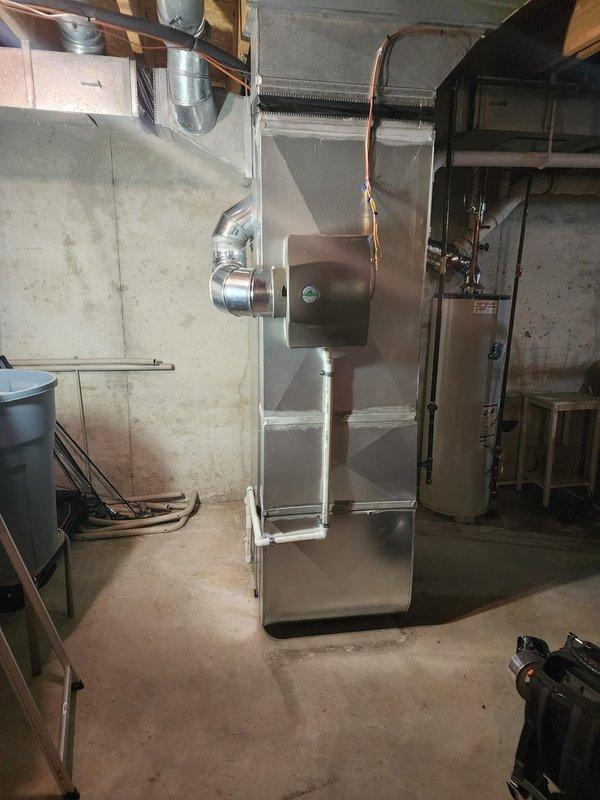 Completed full HVAC system installation including Lennox furnace, air conditioning unit, S40 smart thermostat, and whole-home humidifier in basement mechanical room. Installed new PVC condensate drainage system with pump assembly and trap, configured supply and return ductwork connections, and ran copper refrigerant lines from outdoor condenser to indoor air handler. All equipment tested and operational, thermostat programmed, and humidifier plumbed to furnace with proper water supply connection.